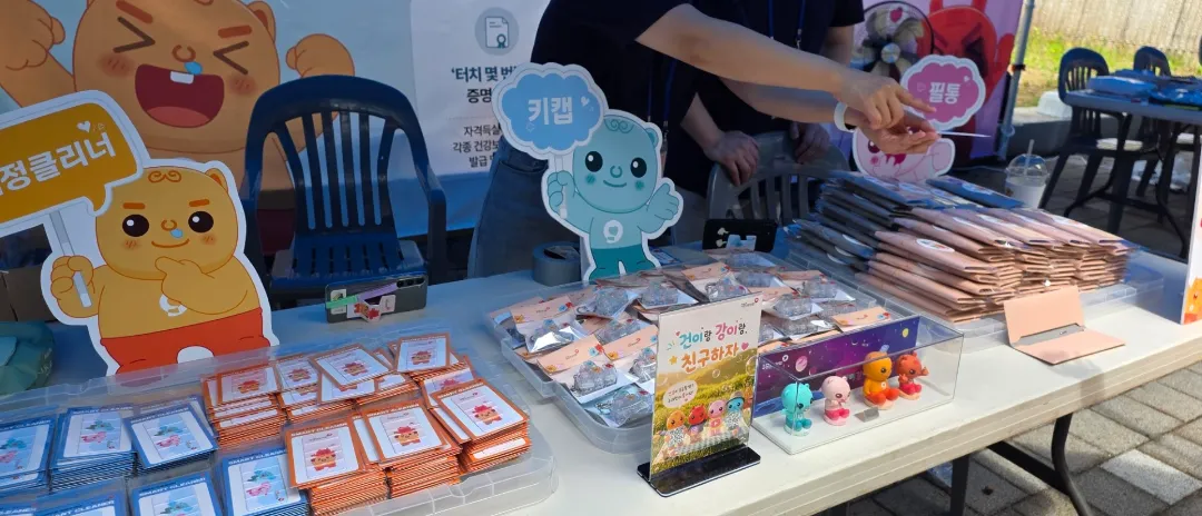 행사장 테이블에 준비된 키캡 키링·액정클리너·필통 등 굿즈 실물